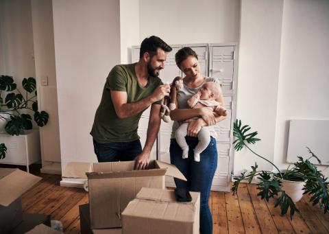 Couple prépare ses carton avec bébé dans les bras