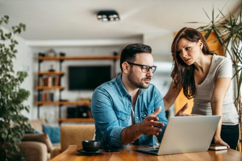 couple inquiet devant ordinateur se demande s'il doit faire remplacer son toit qui contient de l'amiante