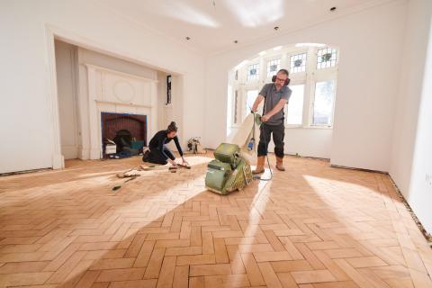 couple en train de rénover le parquet du salon