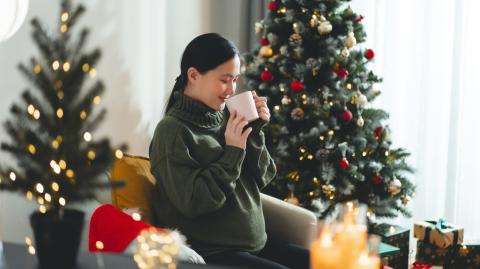Femme buvant un thé dans un décor de Noël