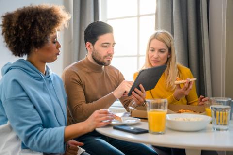 Colocataires lisant sur une tablette pendant le petit déjeuner.