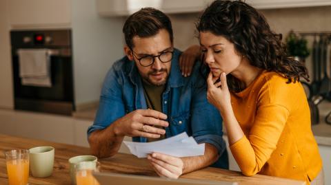 Un couple découvre inquiet le contenu d'un courrier recommandé dans sa cuisine