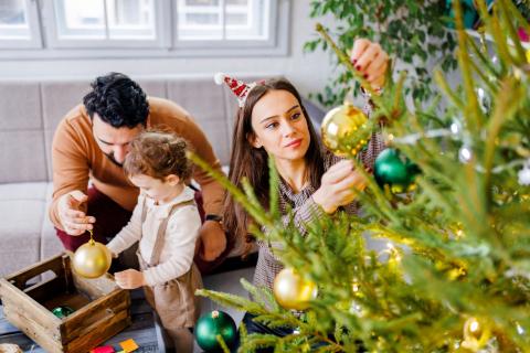 Une famille décore son sapin de noël 