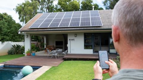 Un homme utilise une application mobile pour contrôler son système d’énergie solaire