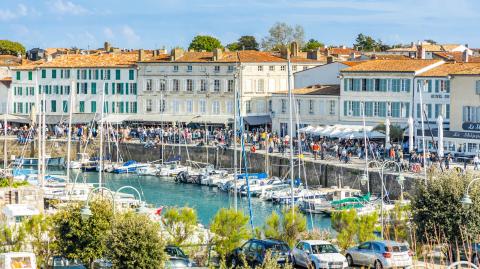 De nombreuses personnes se promènent sur les quais du port de plaisance de Saint-Martin-de-Ré, près de La Rochelle