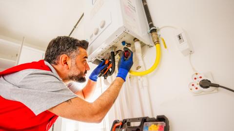Un technicien assure la réparation d'une chaudière à gaz dans un logement