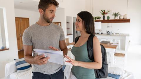 Un jeune homme et une étudiante échangent autour du règlement intérieur de la colocation