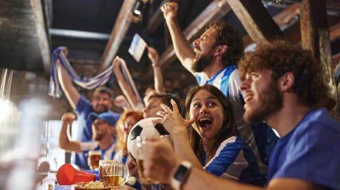 Des supporters de foot français s'enthousiasment devant un match de leur équipe diffusé dans un pub