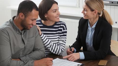 Un couple signe des documents chez le notaire 