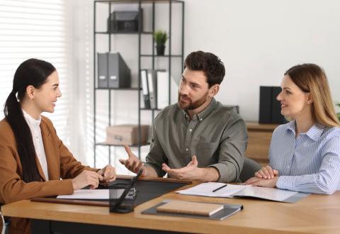 Couple signe l'acte de vente chez le notaire.