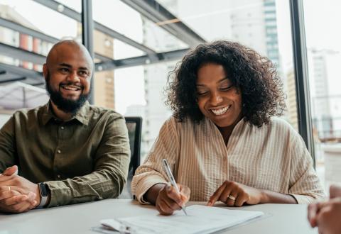 Couple signant un contrat de vente.