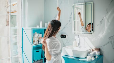 Routine matinale d’une femme asiatique dans une salle de bain lumineuse et moderne