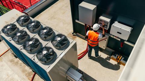 Un technicien travaille sur le système de climatisation sur le toit d'un immeuble