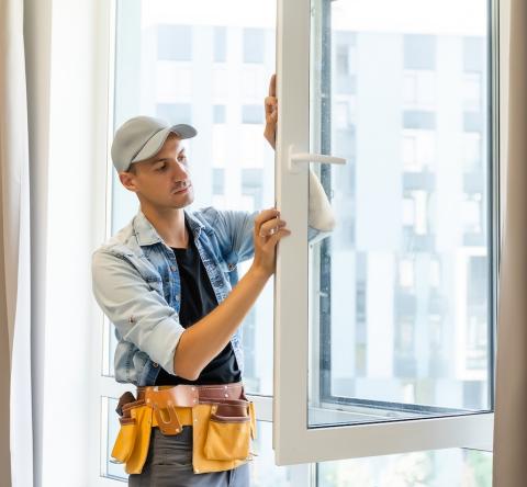 Un artisan termine l'installation d'une nouvelle fenêtre dans un logement. ©GettyImages