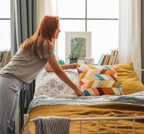 Jeune fille aménageant un coin nuit dans un studio