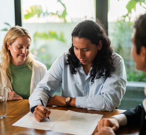 Un couple signe une offre d'achat sur les conseils d'un agent immobilier