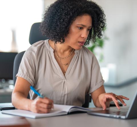 Une femme d'origine hispanique travaille sur son ordinateur portable dans son bureau