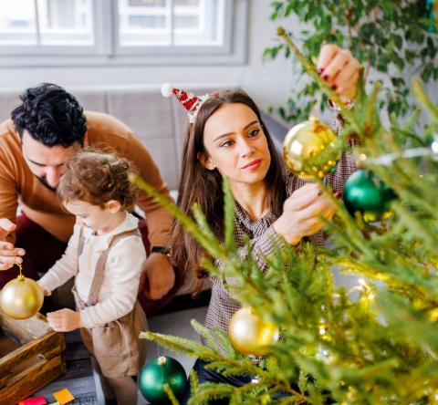 Une famille décore son sapin de noël 