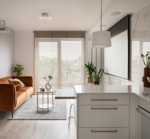 Salon lumineux avec canapé marron cuivré. 