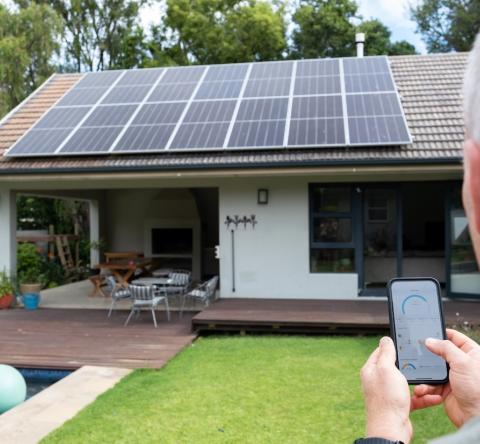 Un homme utilise une application mobile pour contrôler son système d’énergie solaire