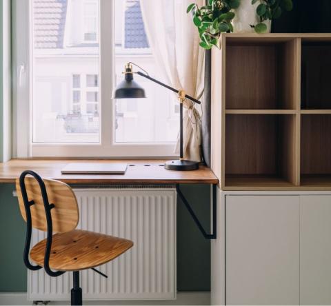 Un radiateur peut être discrètement intégré sous un meuble comme un bureau. © brizmaker - Getty images