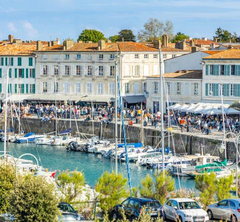 De nombreuses personnes se promènent sur les quais du port de plaisance de Saint-Martin-de-Ré, près de La Rochelle
