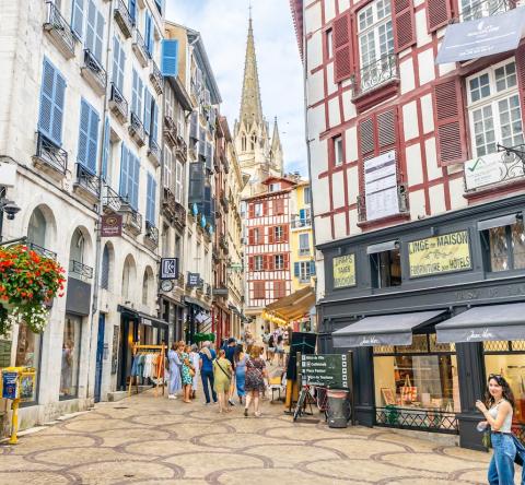 Touristes marchant dans une rue commerçante du centre de Bayonne, France