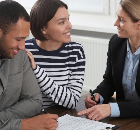 Un couple signe des documents chez le notaire 