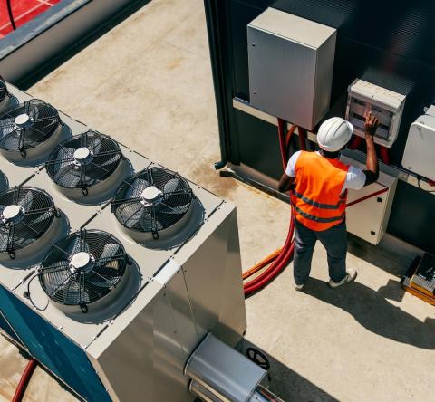 Un technicien travaille sur le système de climatisation sur le toit d'un immeuble